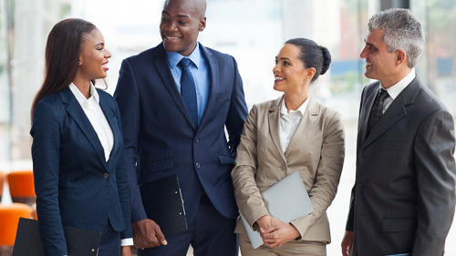 Group of professional men and women standing in discussion